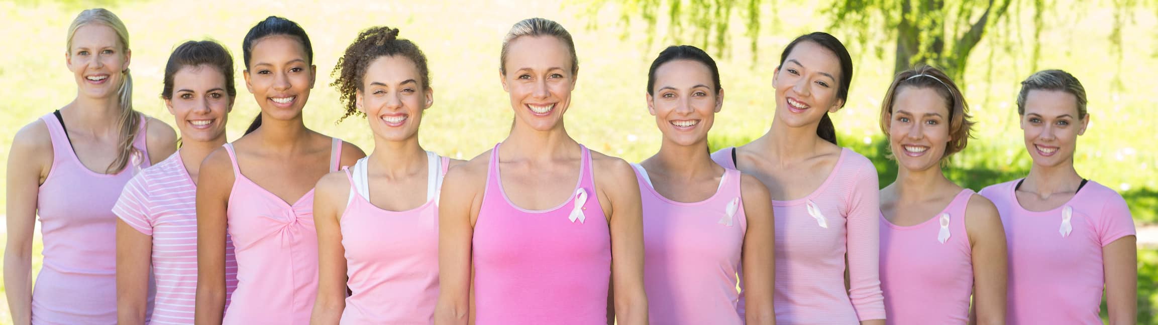 Smiling women in pink for breast cancer awareness Breast Reconstruction in Boston, MA